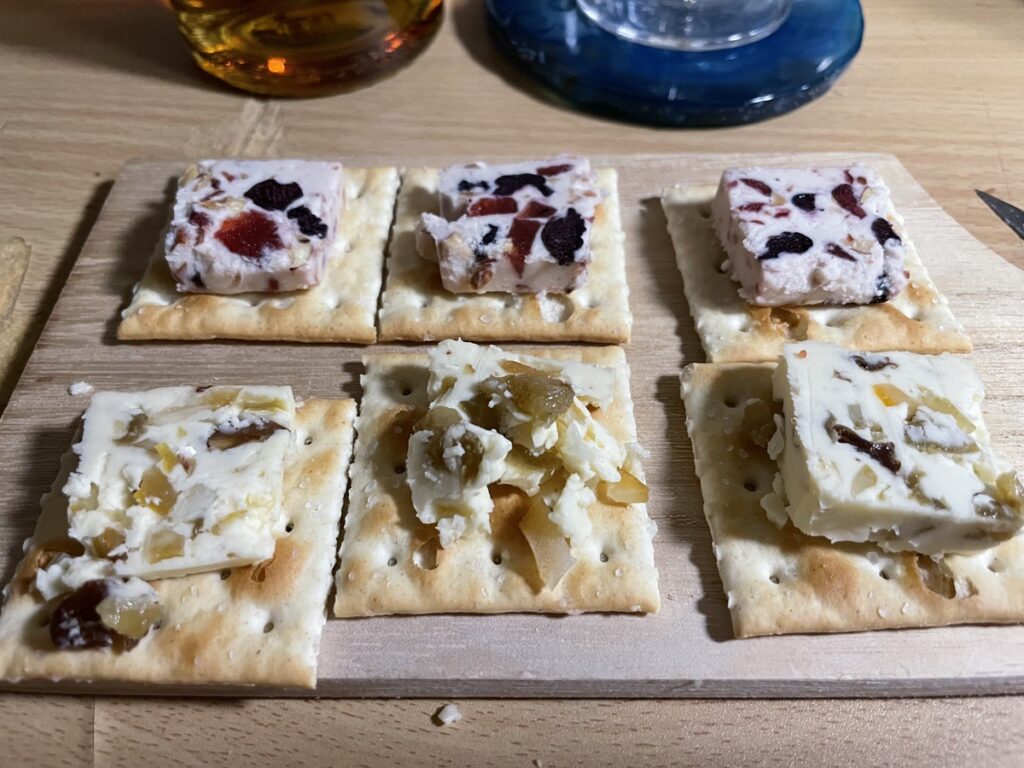 フルーツバターをクラッカーにのせたおつまみの写真