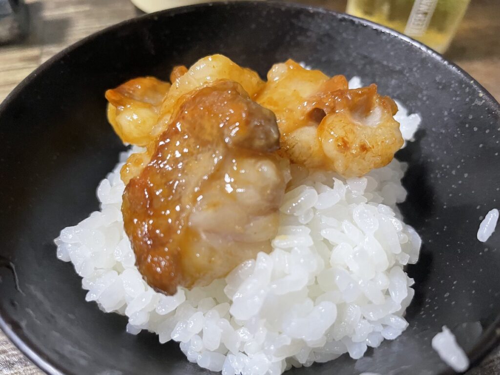 白飯の上に幸福亭の大トロホルモン西京焼きをのせた締めの一品の写真